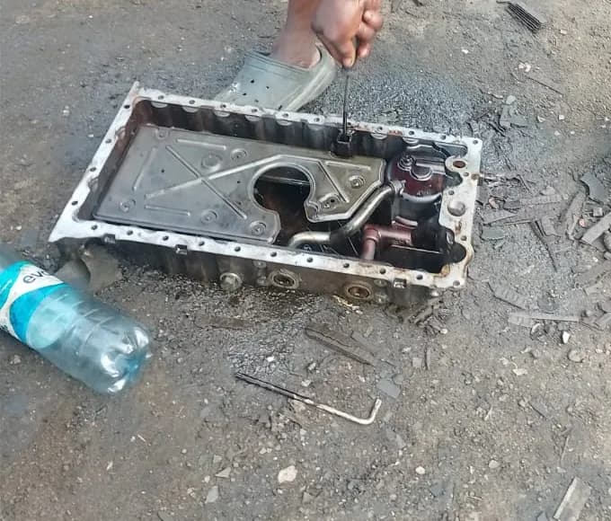Engine sump pan removed and being cleaned during an engine repair at ONYEBEST, Ladipo Volvo Plaza, Mushin